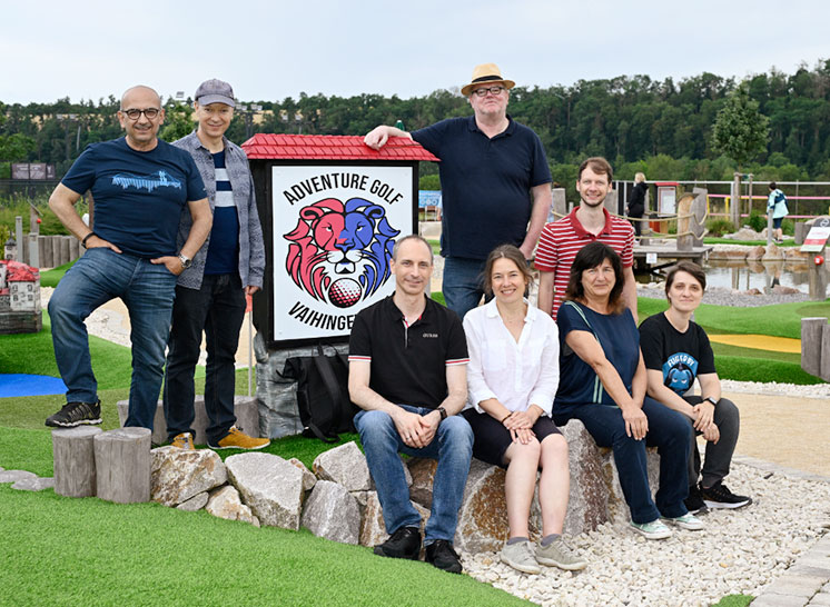 Das Himbeerrot-Team vor dem Adventure Golf Vaihingen Schild mit dem rot-blauen Löwen